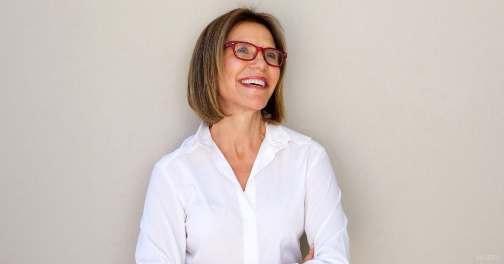 Mature woman wearing glasses looking up and smiling (model)