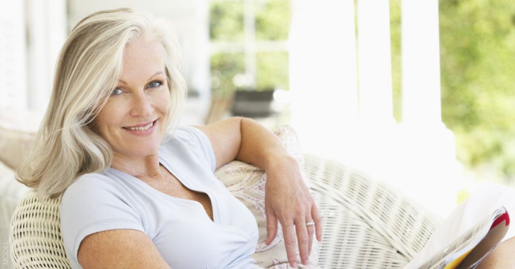 Mature woman sitting on a porch smiling (model)