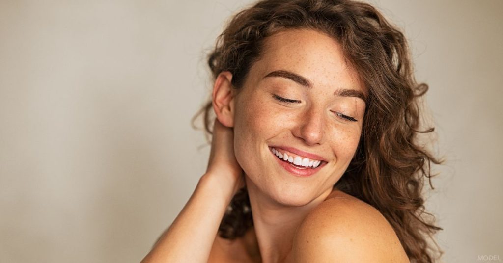 Beautiful woman looking down over her shoulder smiling (model)